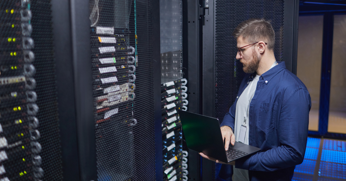 profissional de TI monitora servidores com no-break 3000VA em data center